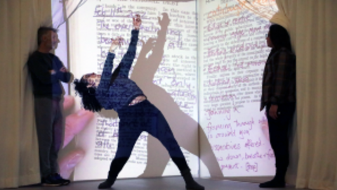 Dancer in front of a projection of a book