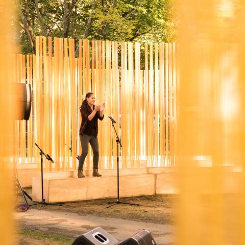 A tap dancer surrounded by orange tubes as part of the Autumn (...Nothing Personal) art installation